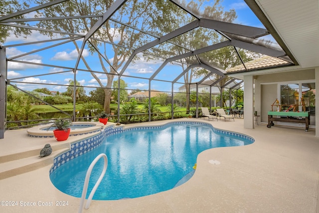 view of pool with glass enclosure, a patio area, and a pool with connected hot tub