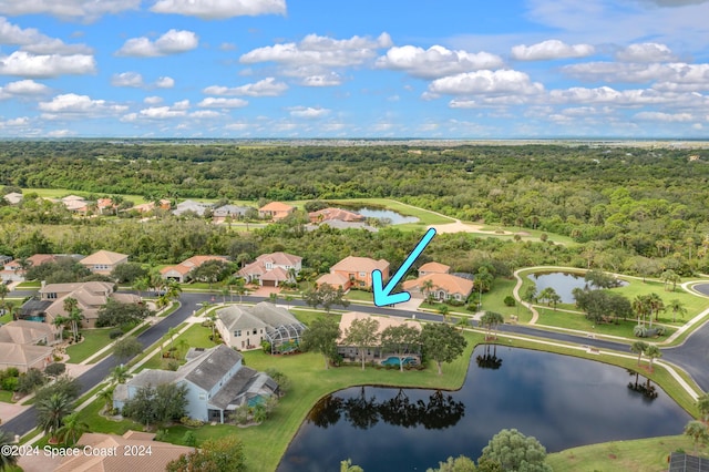 birds eye view of property with a residential view, a water view, and a view of trees