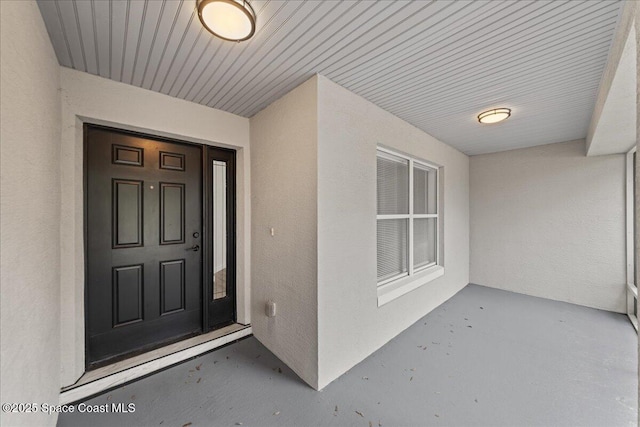 doorway to property featuring stucco siding