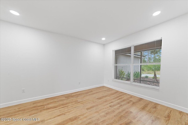 unfurnished room featuring baseboards, wood finished floors, and recessed lighting