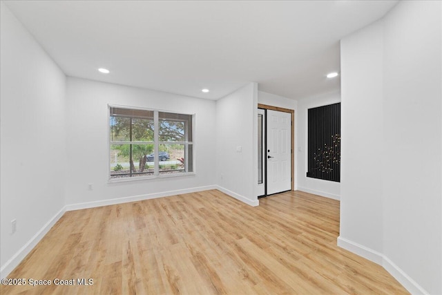 unfurnished room featuring recessed lighting, light wood-style flooring, and baseboards