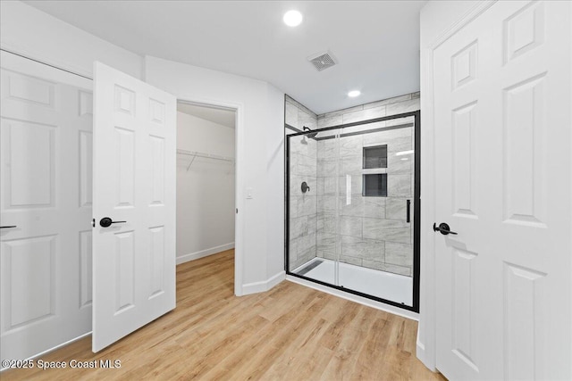 full bath with a stall shower, baseboards, visible vents, wood finished floors, and recessed lighting