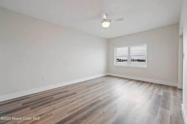 unfurnished room featuring ceiling fan, baseboards, and wood finished floors