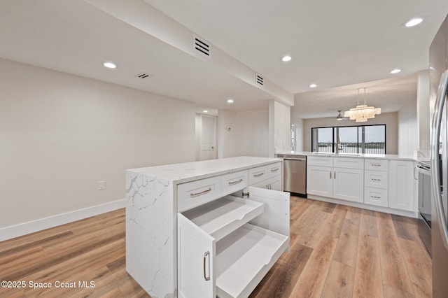 kitchen featuring visible vents, baseboards, light wood finished floors, and stainless steel dishwasher