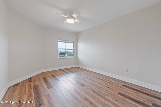 spare room with ceiling fan, baseboards, and wood finished floors