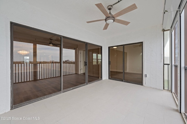 unfurnished sunroom featuring a ceiling fan