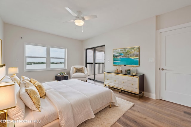 bedroom with access to exterior, a ceiling fan, baseboards, and wood finished floors