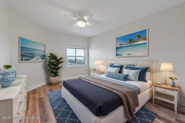 bedroom with a ceiling fan, baseboards, and wood finished floors