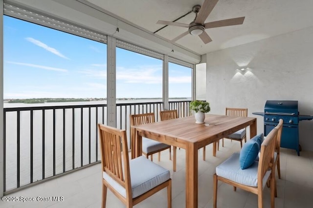 sunroom with a water view and a ceiling fan