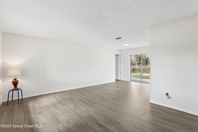 unfurnished room featuring baseboards and wood finished floors