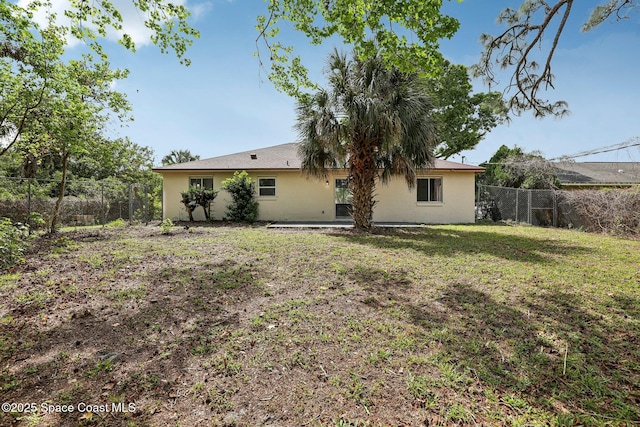 back of property with a yard, a fenced backyard, and stucco siding