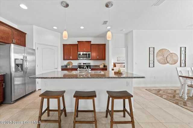 kitchen with a breakfast bar area, light tile patterned floors, stainless steel appliances, visible vents, and a sink