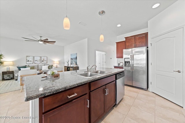 kitchen with pendant lighting, stainless steel appliances, a sink, and light tile patterned flooring