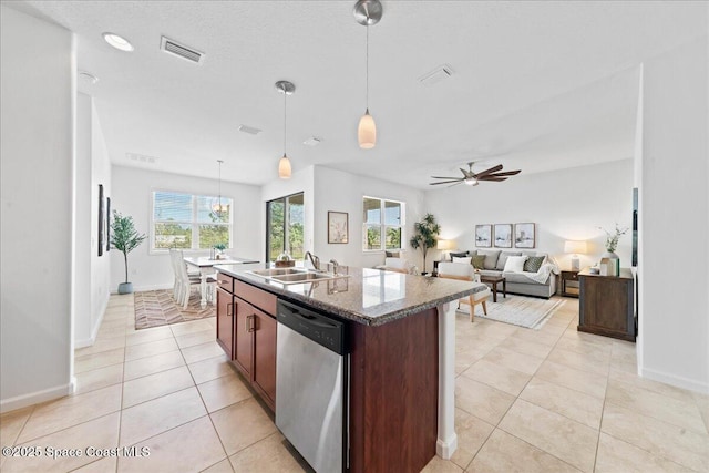 kitchen featuring light tile patterned floors, visible vents, dishwasher, a kitchen island with sink, and a sink