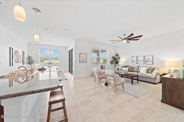 living room with light tile patterned floors, ceiling fan, visible vents, and a wealth of natural light