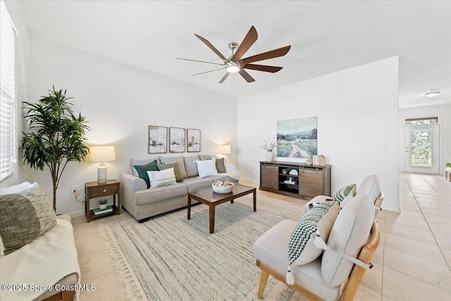 living area with ceiling fan and light tile patterned floors