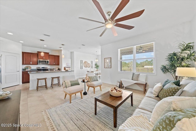 living room featuring recessed lighting, light tile patterned flooring, ceiling fan, and baseboards