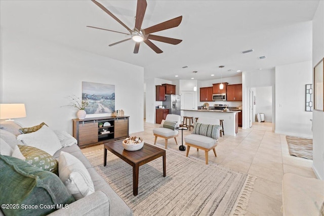 living area featuring light tile patterned floors, recessed lighting, visible vents, ceiling fan, and baseboards