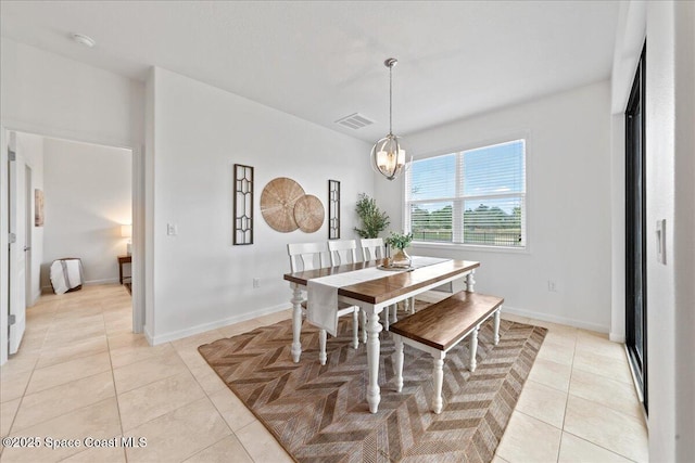 dining space featuring visible vents, a chandelier, baseboards, and light tile patterned flooring