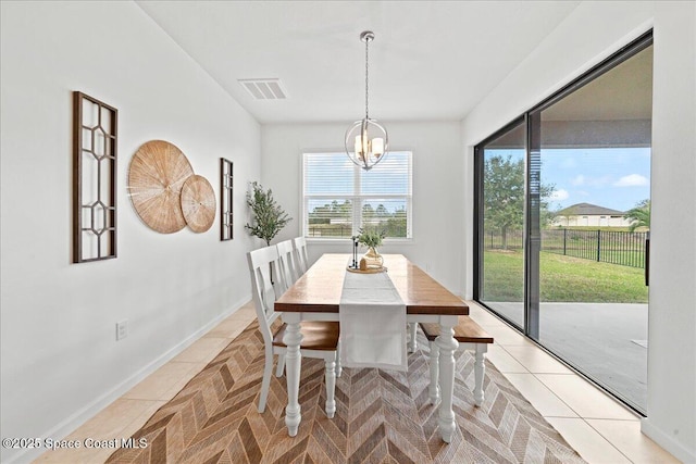 dining area with a chandelier, visible vents, baseboards, and light tile patterned flooring