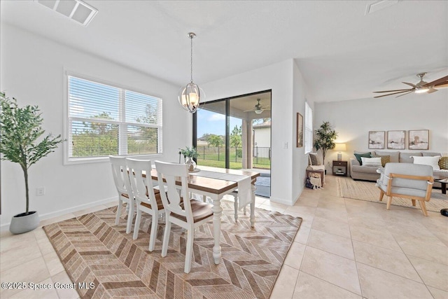 dining room with light tile patterned floors, baseboards, visible vents, and ceiling fan with notable chandelier