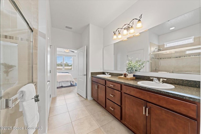 bathroom featuring a stall shower, connected bathroom, a sink, and tile patterned floors