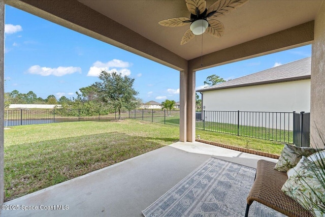 view of patio / terrace with a water view, a fenced backyard, and a ceiling fan