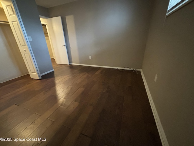 1341 S Patrick Dr, Satellite Beach, FL 32937 - unfurnished bedroom featuring dark wood-type flooring and baseboards