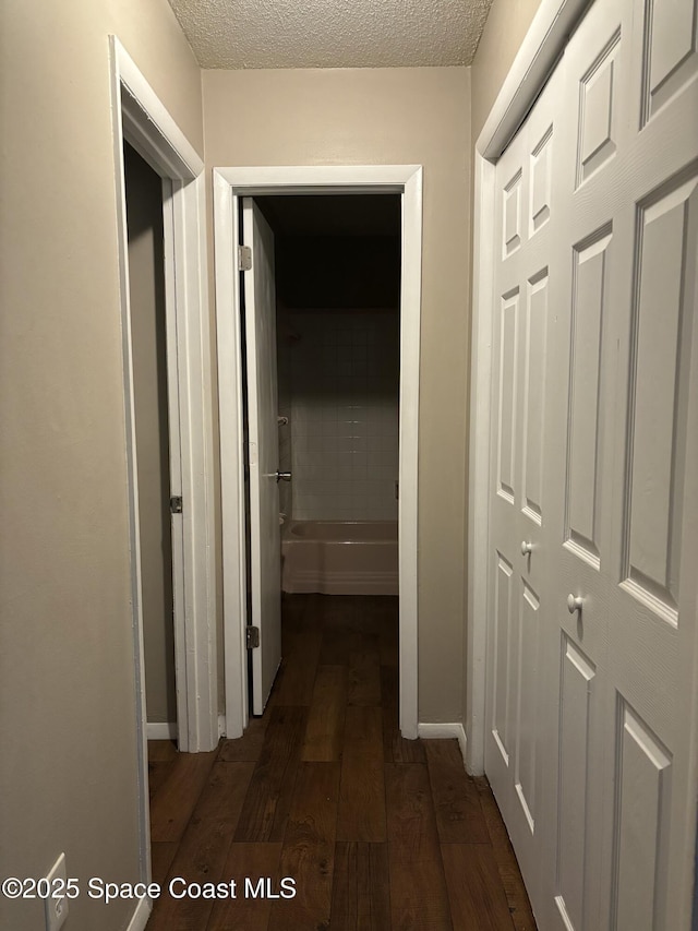 1341 S Patrick Dr, Satellite Beach, FL 32937 - hallway with baseboards, dark wood finished floors, and a textured ceiling
