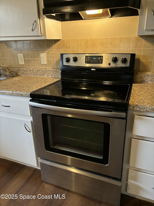 1341 S Patrick Dr, Satellite Beach, FL 32937 - kitchen with white cabinets, stainless steel range with electric stovetop, light countertops, and dark wood-style flooring