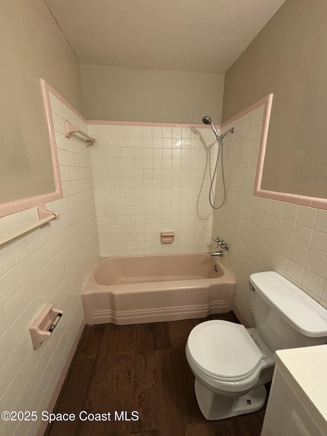 1341 S Patrick Dr, Satellite Beach, FL 32937 - bathroom featuring toilet, shower / washtub combination, wood finished floors, and tile walls