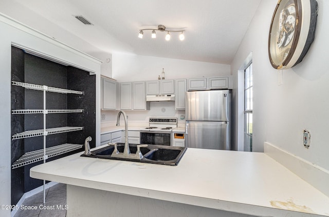 kitchen featuring white range with electric stovetop, lofted ceiling, visible vents, freestanding refrigerator, and under cabinet range hood