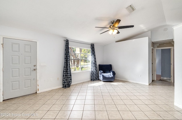 interior space featuring light tile patterned floors, visible vents, a ceiling fan, vaulted ceiling, and baseboards