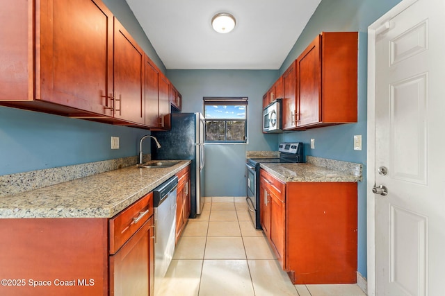 kitchen featuring light tile patterned floors, stainless steel appliances, a sink, and light stone countertops