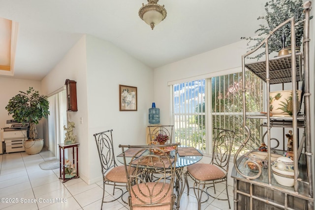 dining room featuring lofted ceiling and light tile patterned floors