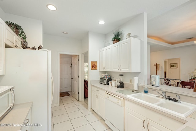 kitchen featuring light tile patterned floors, recessed lighting, light countertops, a sink, and white appliances