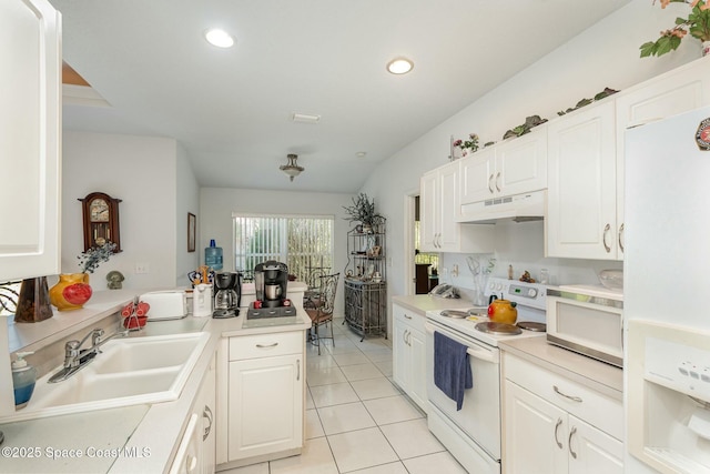 kitchen featuring light tile patterned floors, under cabinet range hood, white appliances, a sink, and white cabinetry