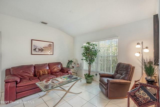 living area with lofted ceiling, visible vents, and light tile patterned floors