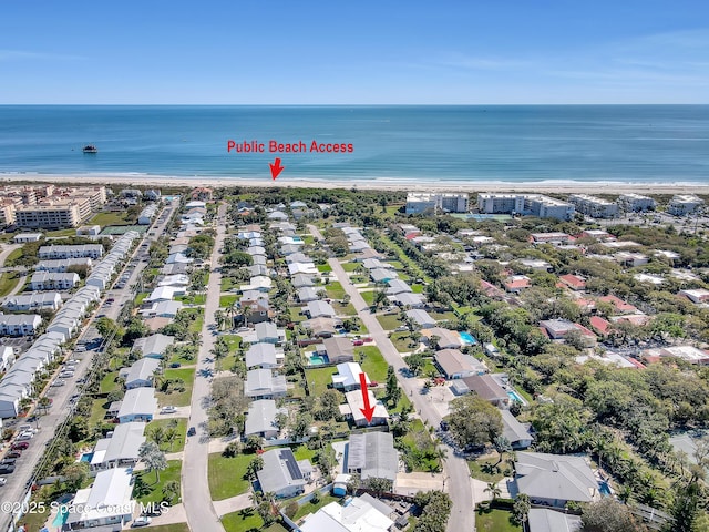 birds eye view of property featuring a water view and a beach view