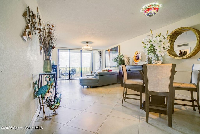 living area with a chandelier, light tile patterned floors, baseboards, and floor to ceiling windows