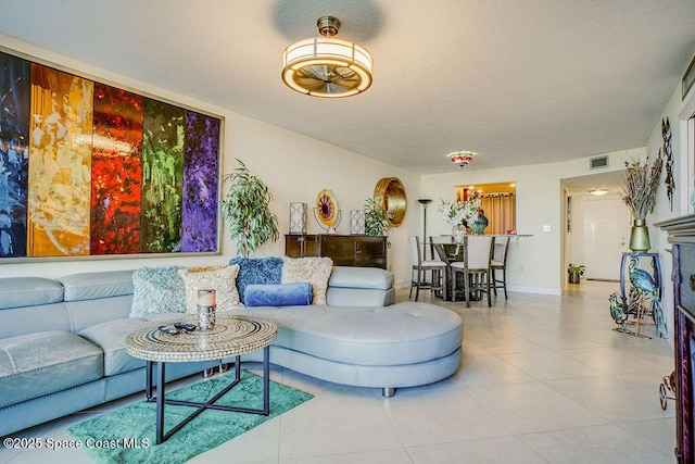 tiled living area featuring visible vents and baseboards