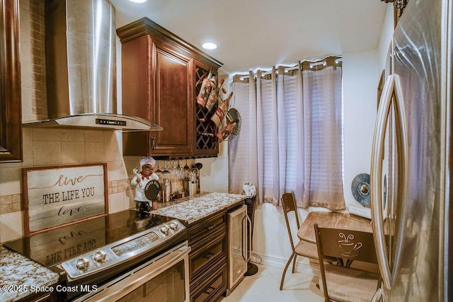 kitchen featuring light tile patterned floors, decorative backsplash, wall chimney exhaust hood, light stone countertops, and stainless steel appliances