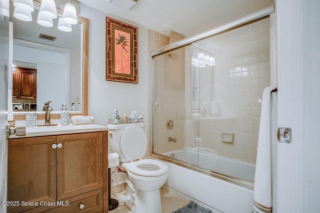 bathroom featuring toilet, combined bath / shower with glass door, vanity, and visible vents