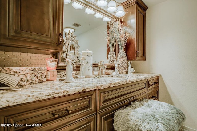 bathroom featuring visible vents, vanity, and decorative backsplash