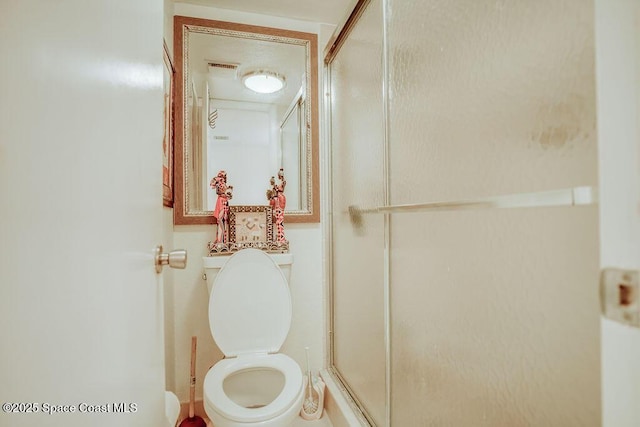 bathroom with toilet, a stall shower, and visible vents