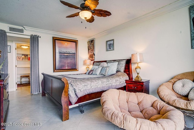 bedroom featuring visible vents, ceiling fan, tile patterned flooring, a textured ceiling, and crown molding