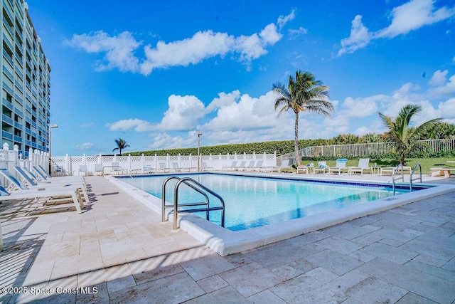 community pool featuring a patio area and fence
