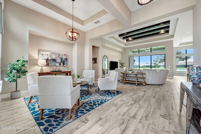 3882 Durksly Dr, Melbourne, FL 32940 - living area with baseboards, visible vents, a towering ceiling, wood finished floors, and a chandelier