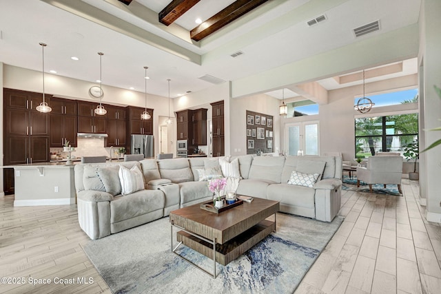 3882 Durksly Dr, Melbourne, FL 32940 - living area featuring wood finish floors, visible vents, a towering ceiling, and a tray ceiling