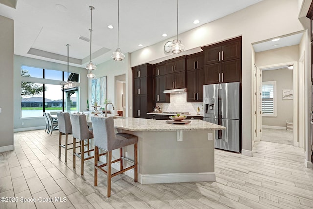 3882 Durksly Dr, Melbourne, FL 32940 - kitchen featuring appliances with stainless steel finishes, a healthy amount of sunlight, under cabinet range hood, and tasteful backsplash